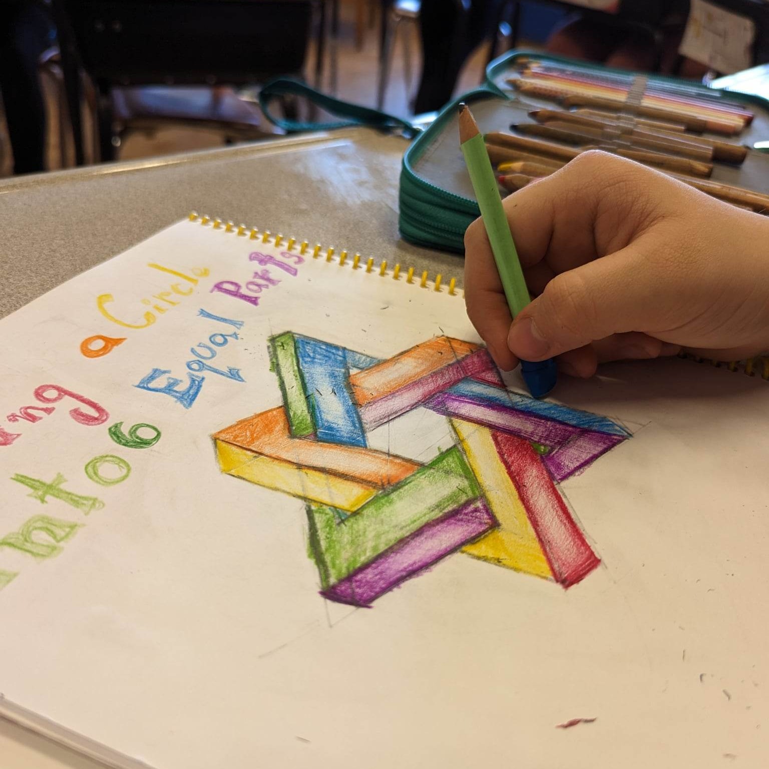 Teacher at blackboard; pointing to writing